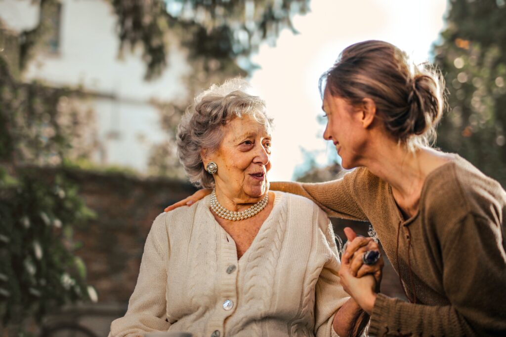 A carer and an older woman sharing a laugh at home